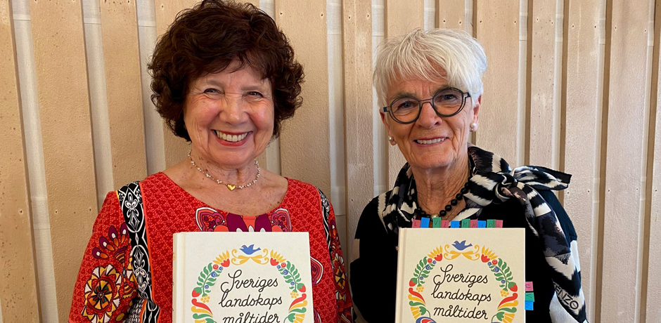 Christina Möller och Ella Nilsson håller upp varsin bok om Landskapsmåltier.