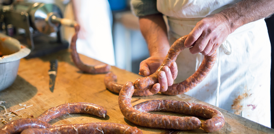 Person håller i en nytillverkad korv som ska snurras.