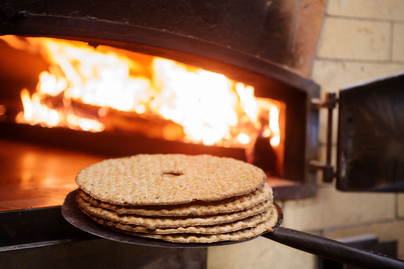 Runda knäckebröd från Skedvi Bröd framför den vedeldade ugnen.